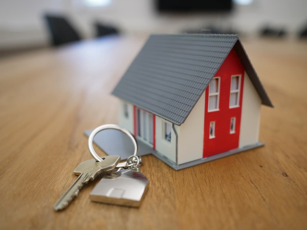 A model house with a set of keys on a table — representing the landlord-tenant relationship at the heart of every portfolio.
